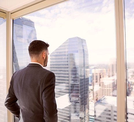 Mann sieht aus dem Fenster und sieht unterschiedliche Gebäude