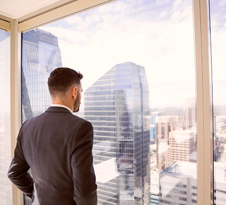 Mann sieht aus dem Fenster und sieht unterschiedliche Gebäude